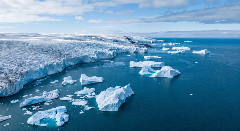 Geleira derretendo com icebergs flutuando no oceano, vista aérea